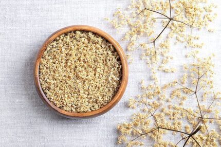 Dried elderflowers in a wooden bowl for organic products, supporting a natural health and wellness lifestyle.